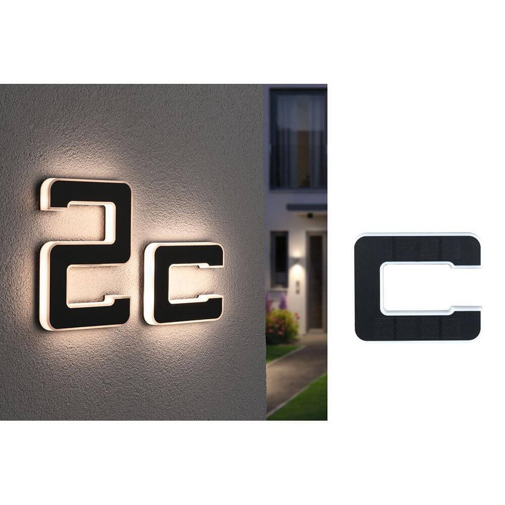 Solar LED Hausnummernleuchte Buchstabe C Schwarz an der Wand montiert, beleuchtet mit warmweißem Licht.