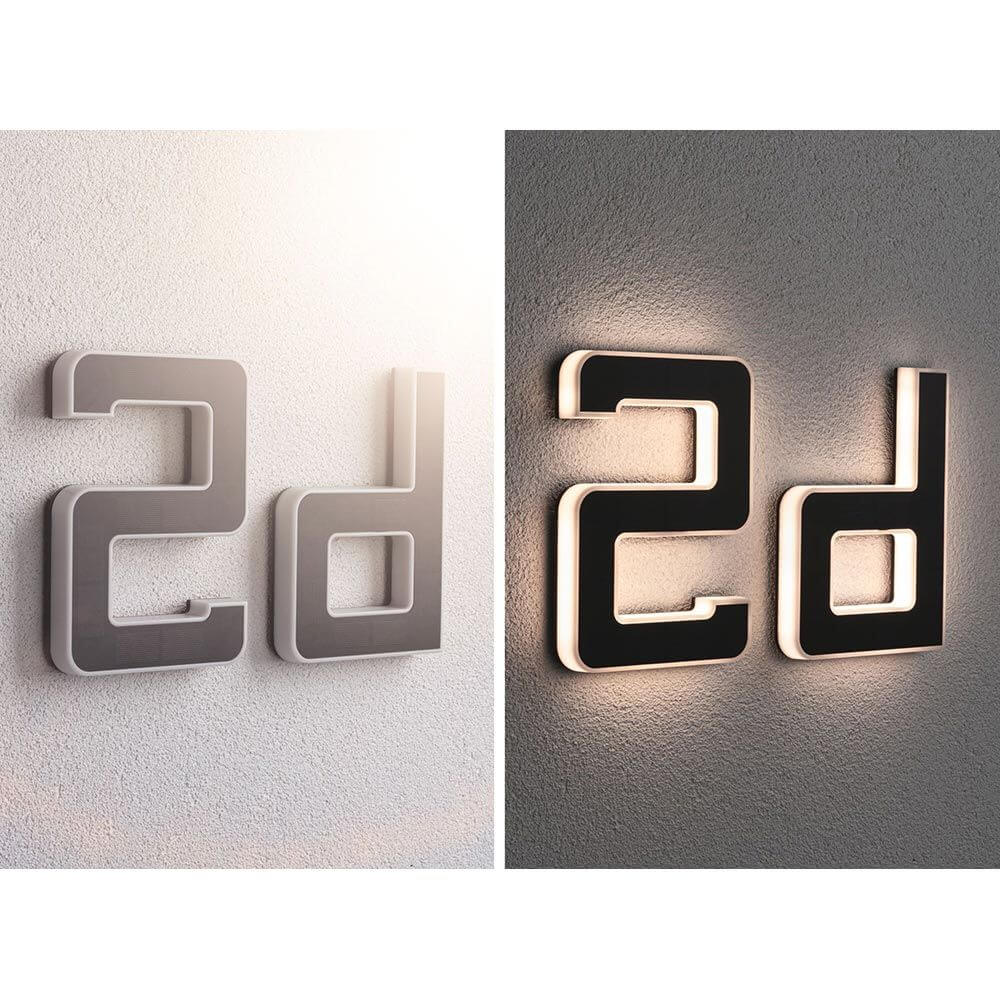 Solar LED Hausnummernleuchte mit Buchstabe D in Schwarz, dekorativ beleuchtet an der Wand.