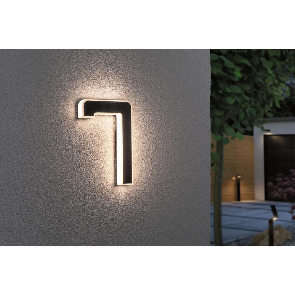 Solar LED Hausnummernleuchte Nummer 7 an einer Wand, warmweiß beleuchtet, ideal als Hausnummernbeleuchtung.