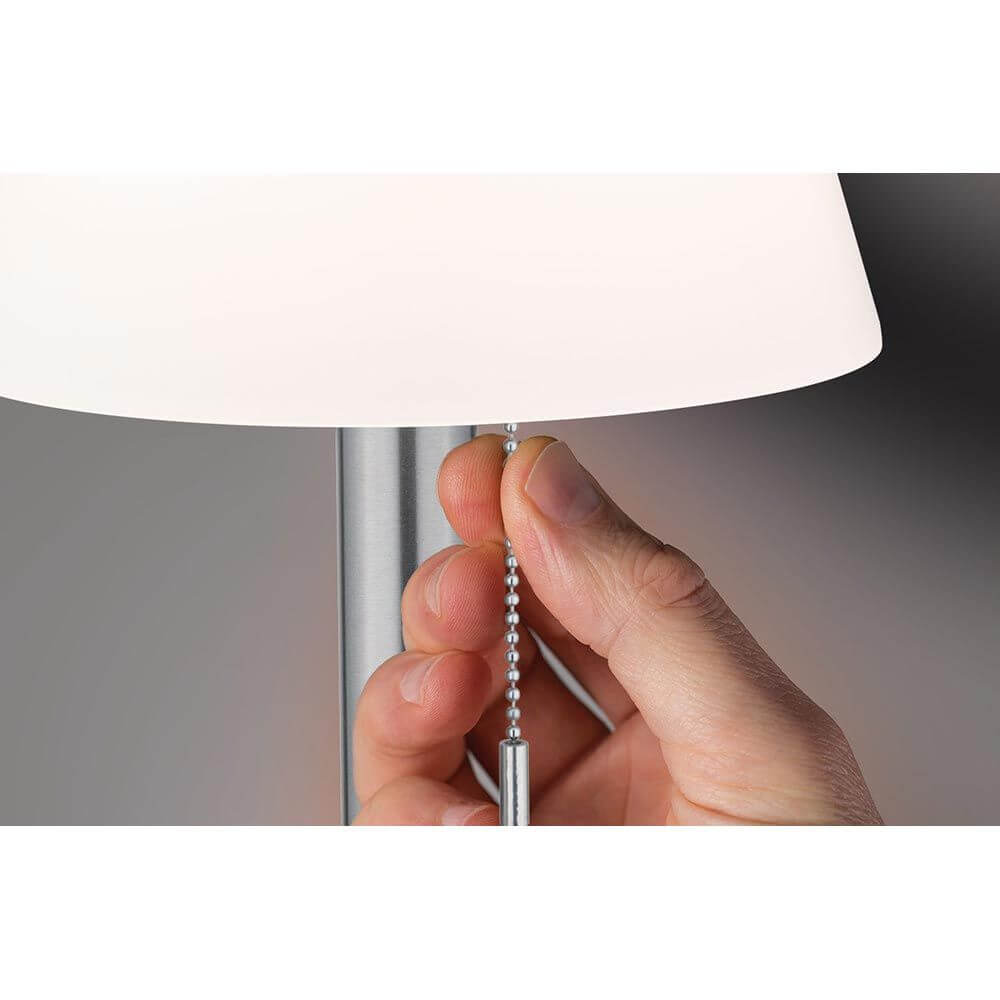 Hand bedient den Kettenzugdimmer der Solar LED Tischleuchte Lillesol Edelstahl