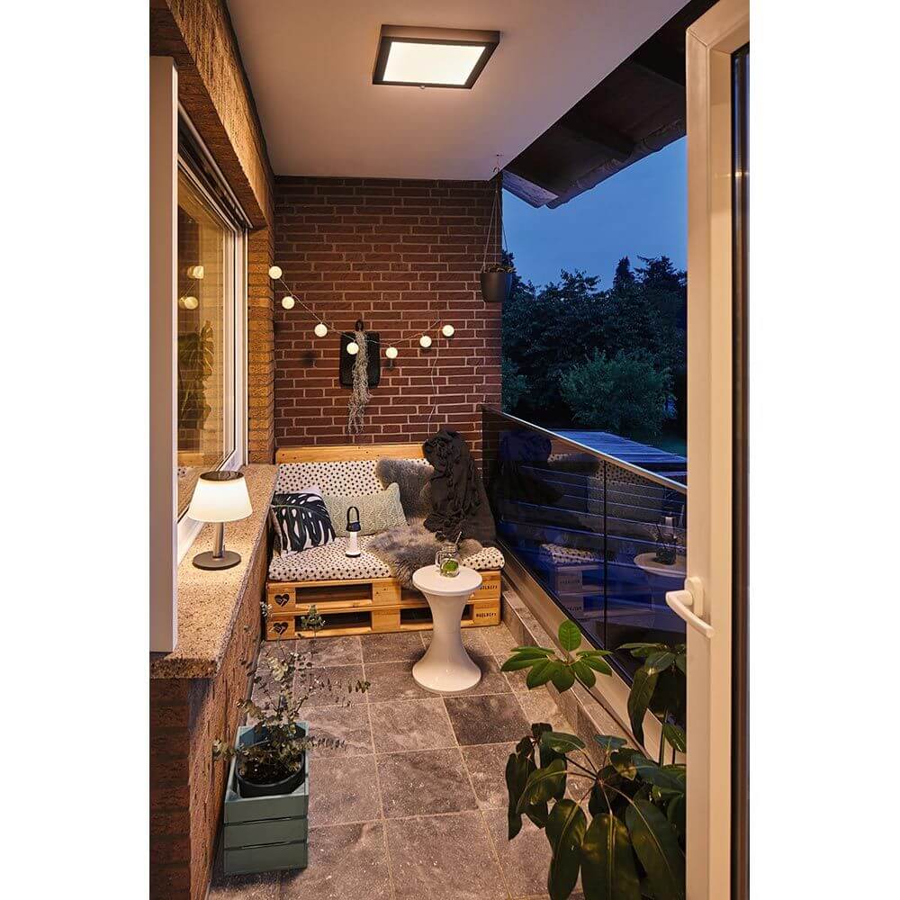 Gemütlicher Balkon mit Solar LED Tischleuchte Lillesol, Palettenmöbel und romantischen Lichtern.