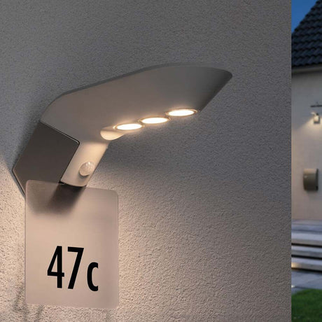Transparentes Hausnummernschild für Solarleuchte Soley mit beleuchteter Nummer 47c an einer Wand.