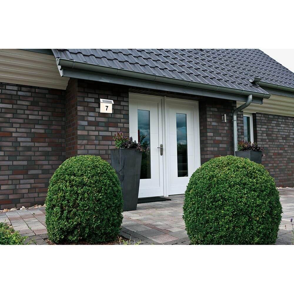 LED Solar Hausnummernleuchte IP44 Edelstahl, Weiß montiert an einem modernen Eingang mit Hausnummer 7.