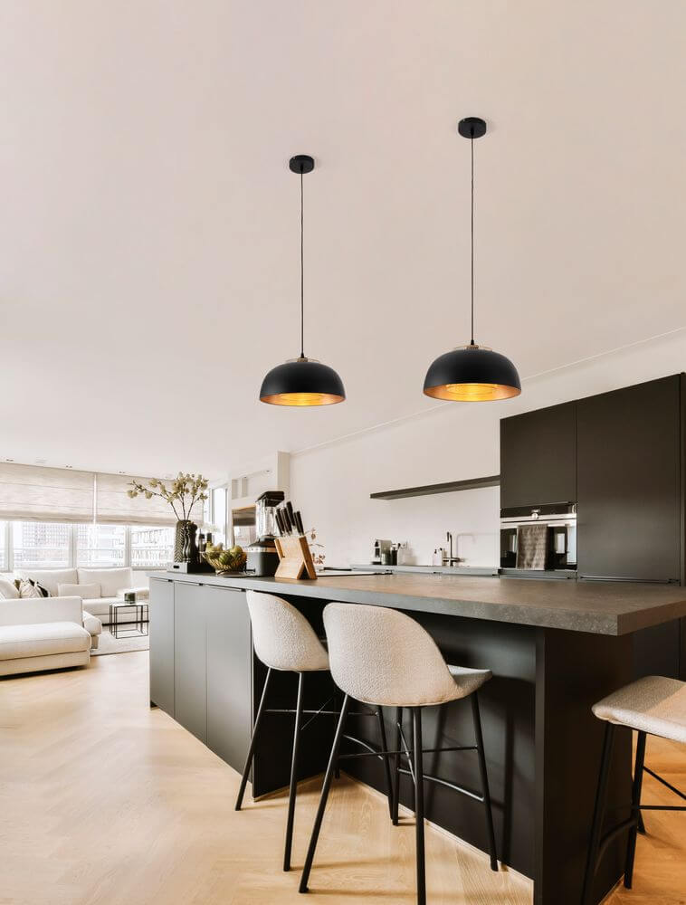 Sqube Pendelleuchte Schwarz, Gold über einer modernen Kücheninsel, minimalistisches Design mit goldener Innenbeschichtung.