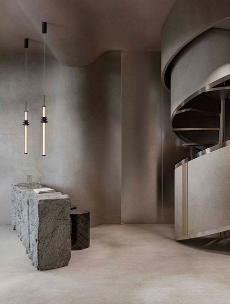 Stalactite suspension verticale Ø 4,5 cm 3000K noir dans un intérieur moderne avec escalier incurvé.