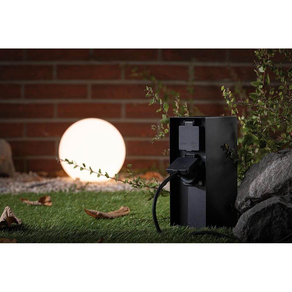 Steckdosensäule Rio Zeitschaltuhr IP44 Schwarz im Außenbereich mit Gartenlicht.