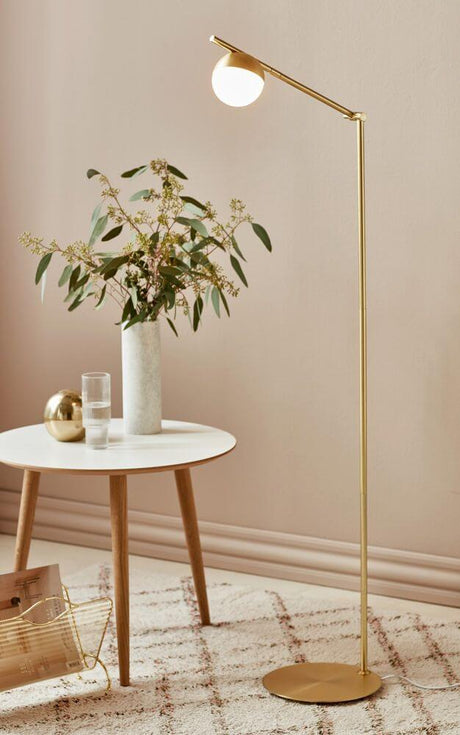 Stehlampe Contina in elegantem Design mit einer kugelförmigen Glaskuppel und goldfarbenem Gestell.