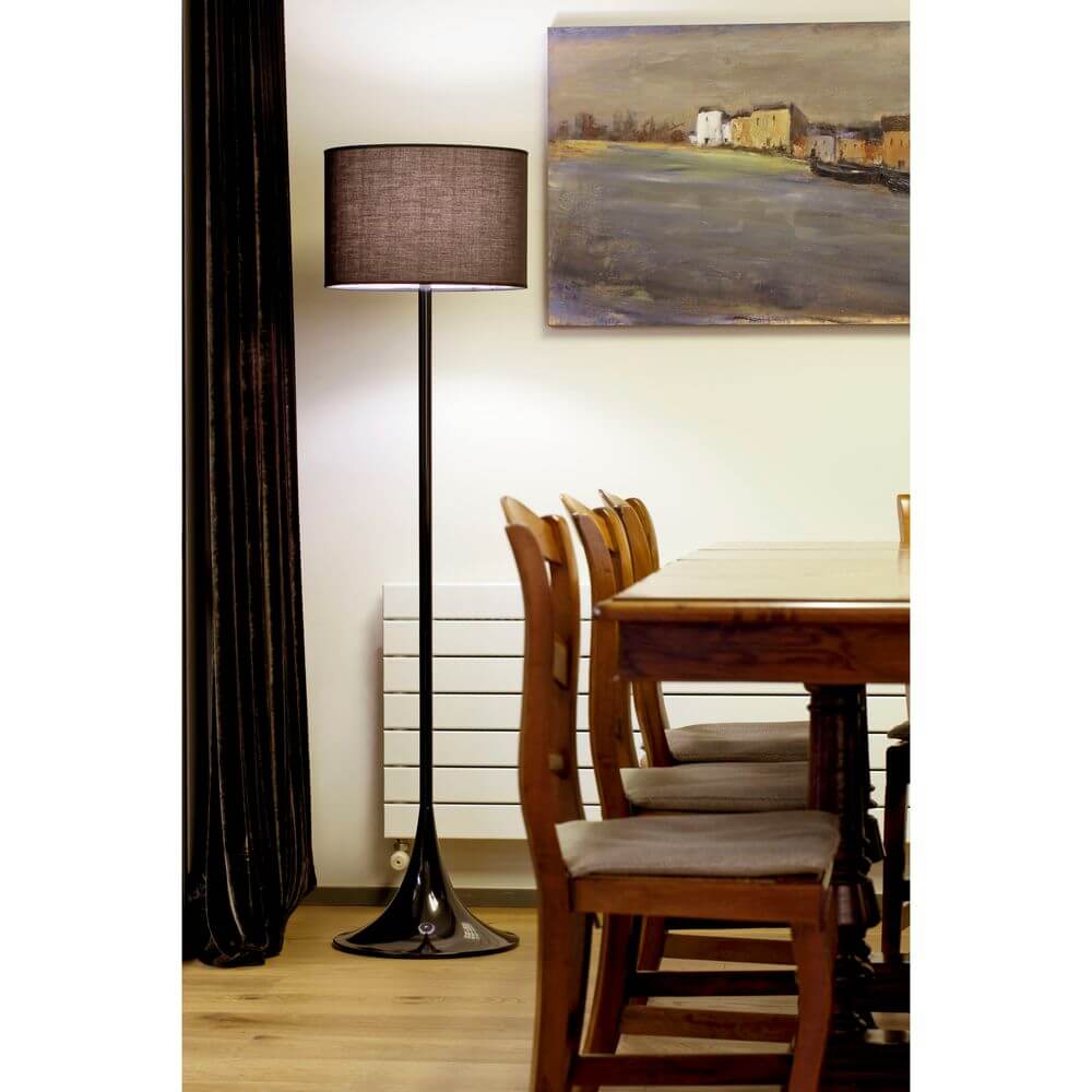 Stehlampe FARO Schwarz in einem hellen Raum mit Holzstuhl und Gemälde im Hintergrund.