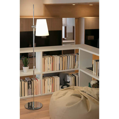 Stehlampe LUPE Chrom, Weiß in modernem Wohnambiente mit Bücherregal und gemütlichem Sessel.