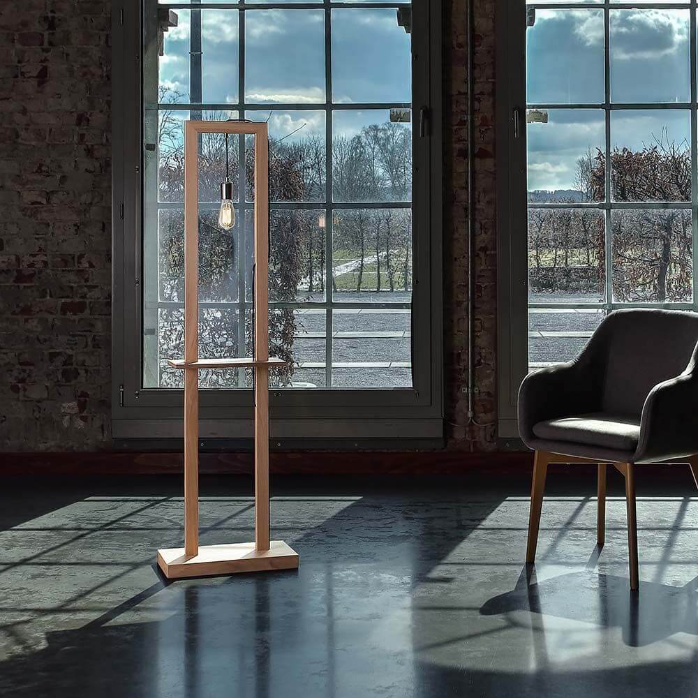 Stehlampe Monopod Eiche-Geölt steht in einem modernem Raum mit großen Fenstern.