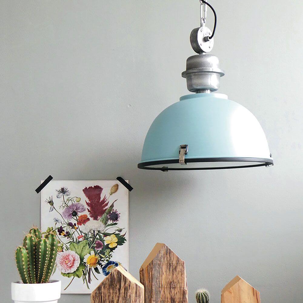 Industrie-Hängeleuchte Bikkel Ø42cm in blauer Farbe, stilvoll über einem Tisch mit Pflanzen und Kunstwerk.