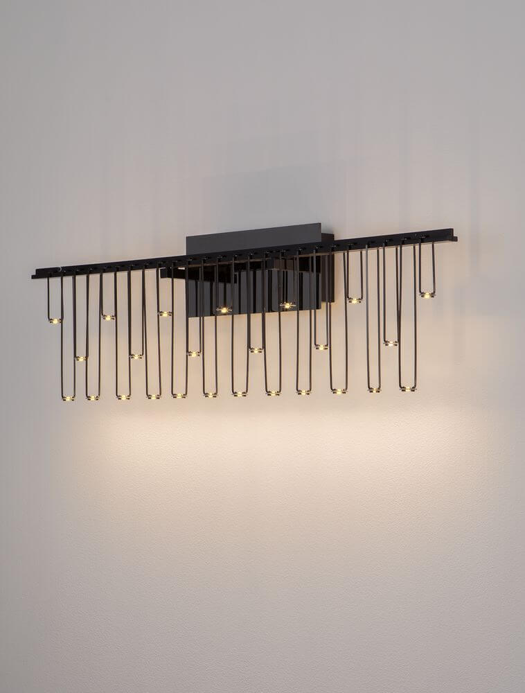 Stellar LED Wandleuchte 25-flammig 3000K in elegantem Schwarz an der Wand, ideal für Flur oder Wohnzimmer.
