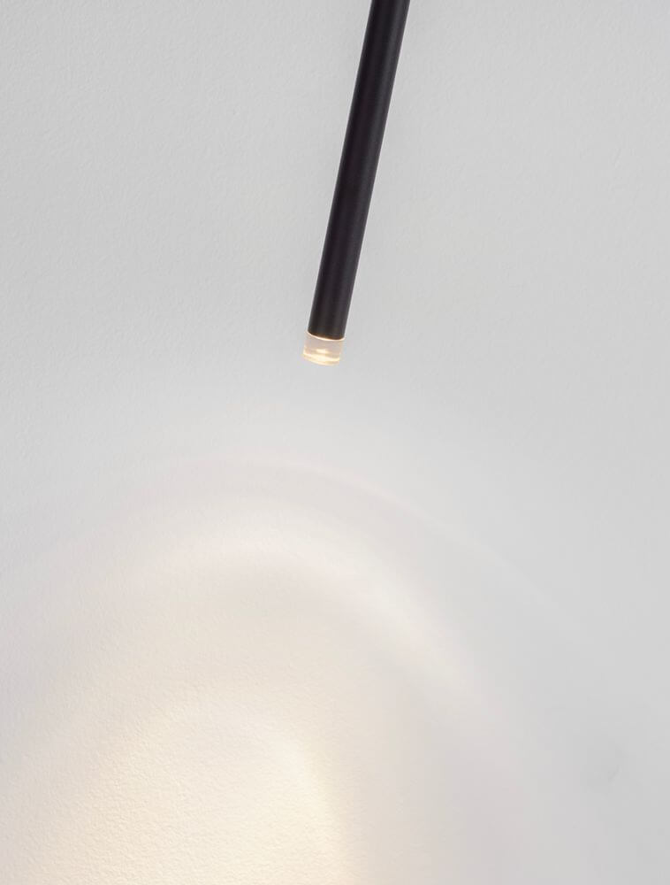 Stilvi Deckenleuchte H 64cm Ø 5cm 3000K in Schwarz mit sanftem Lichtschein auf der Wand.