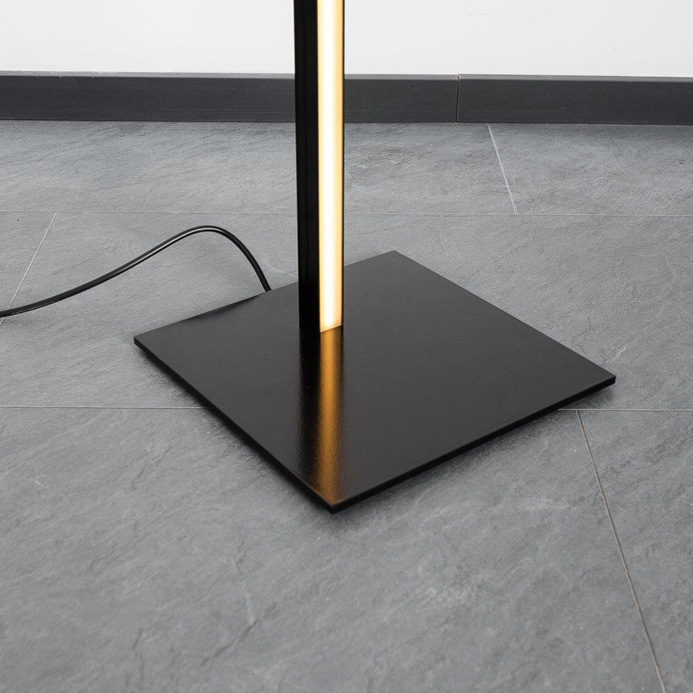 Basis der Sting Blackline LED-Stehleuchte in Schwarz auf grauem Boden, mit schmalem Aluminium-Profil und Kabel.