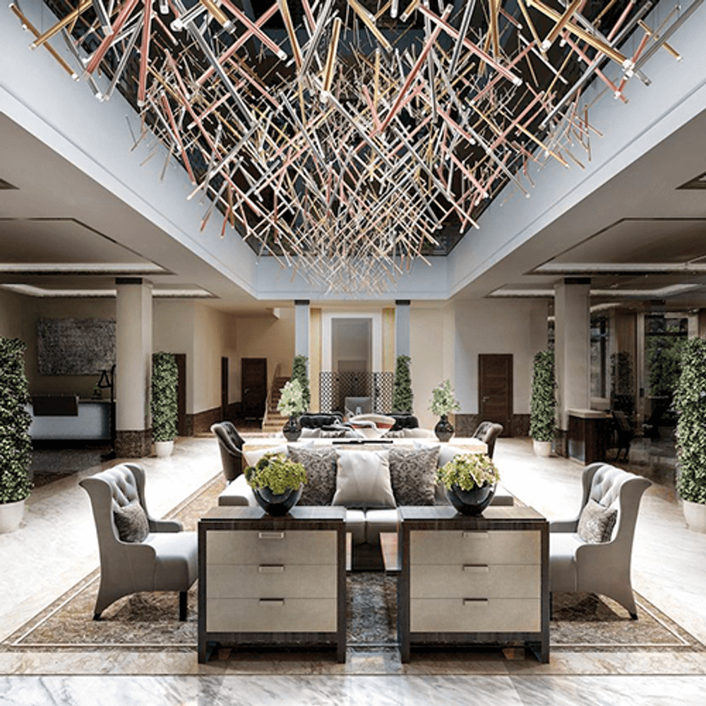 Lodes A-Tube Nano Duo LED Pendellampe in einem eleganten Lobby-Design mit modernen Möbeln und Pflanzen.