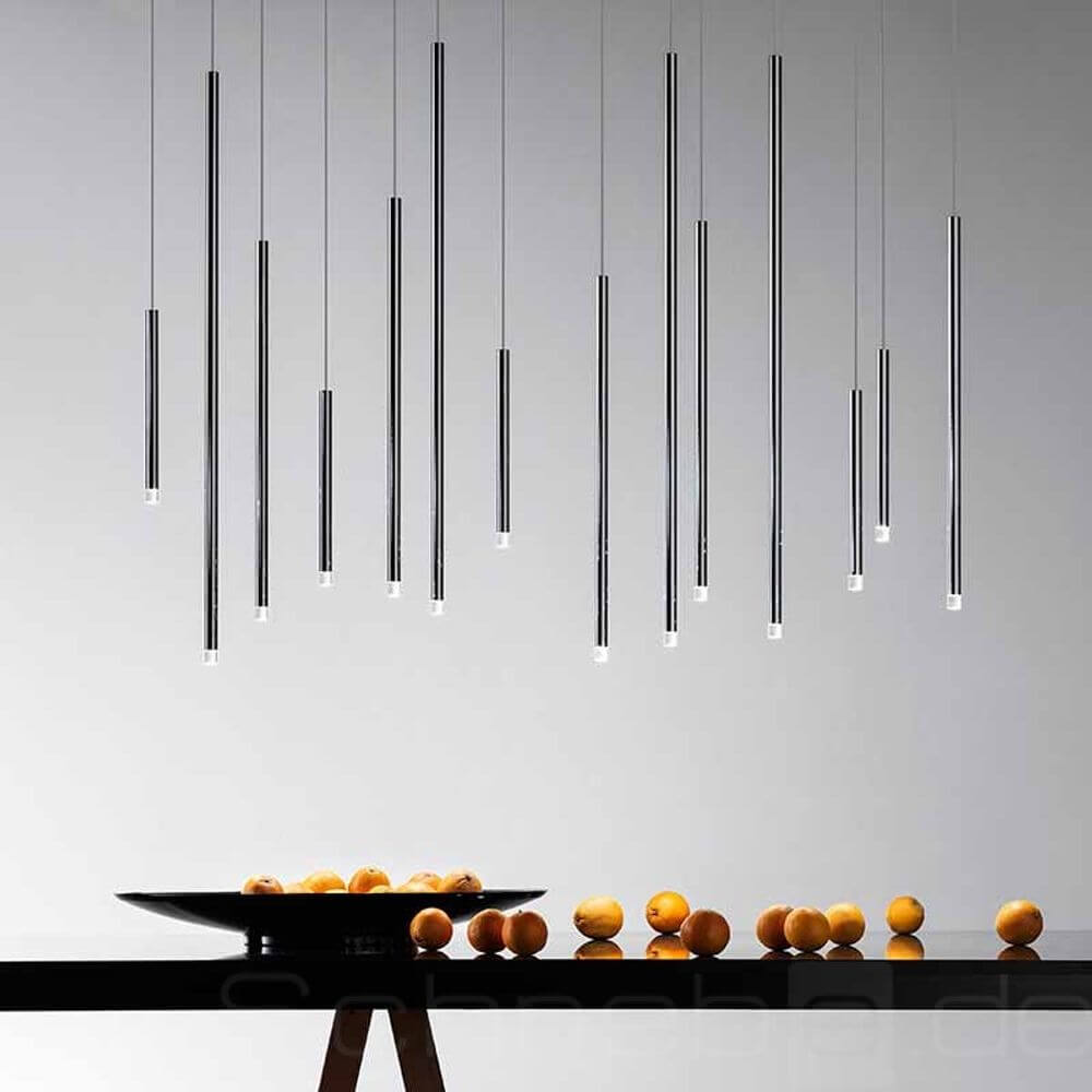 Moderne Lodes A-Tube Nano LED Hängelampe in verschiedenen Längen über einem Tisch mit Obst.