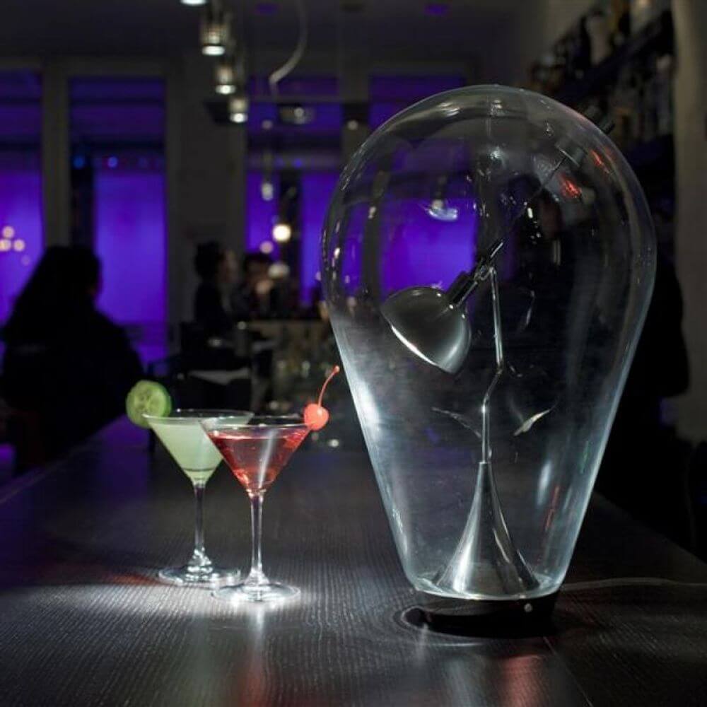 Lodes Blow LED Tischlampe mundgeblasen mit Cocktails in einer stilvollen Umgebung.