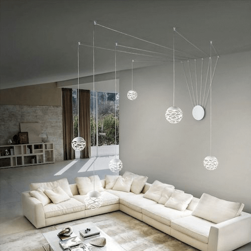 Lodes Kelly Cluster Sphere LED Pendellampe in modernem Wohnraum mit eleganter Couch und skulpturalen Leuchten.