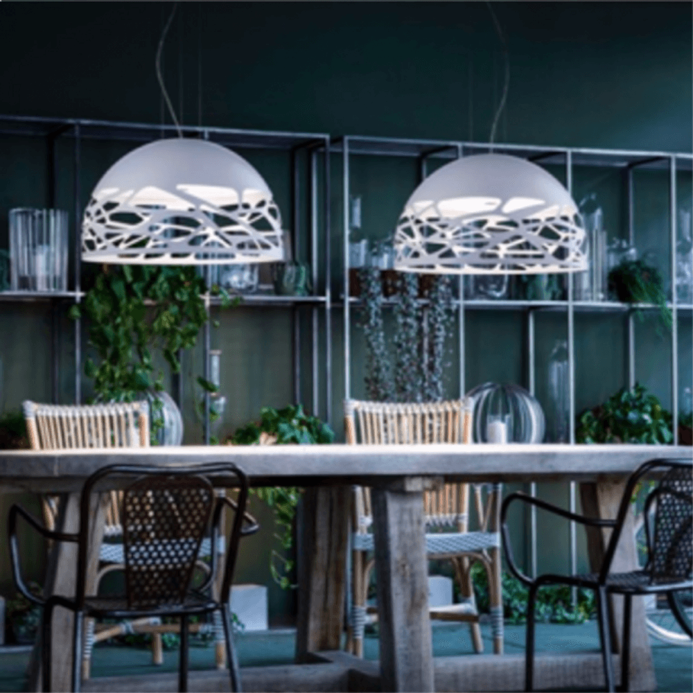 Lodes Kelly Dome Hängelampe über einem Tisch, elegantes Design mit Licht- und Schattenspiel.