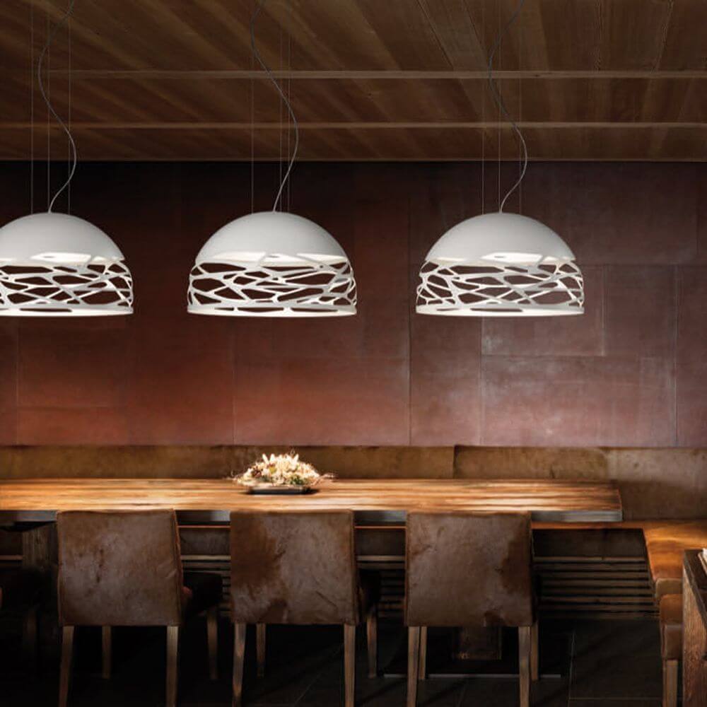 Lodes Kelly Dome Hängelampe im modernen Esszimmer über Holztisch mit eleganten Stühlen.