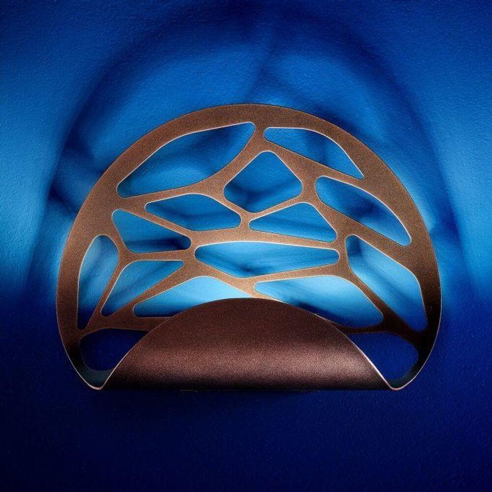 Lodes Kelly Wandlampe mit modernem Design und filigranen Laserschnitten, schaffend ein Spiel aus Licht und Schatten.