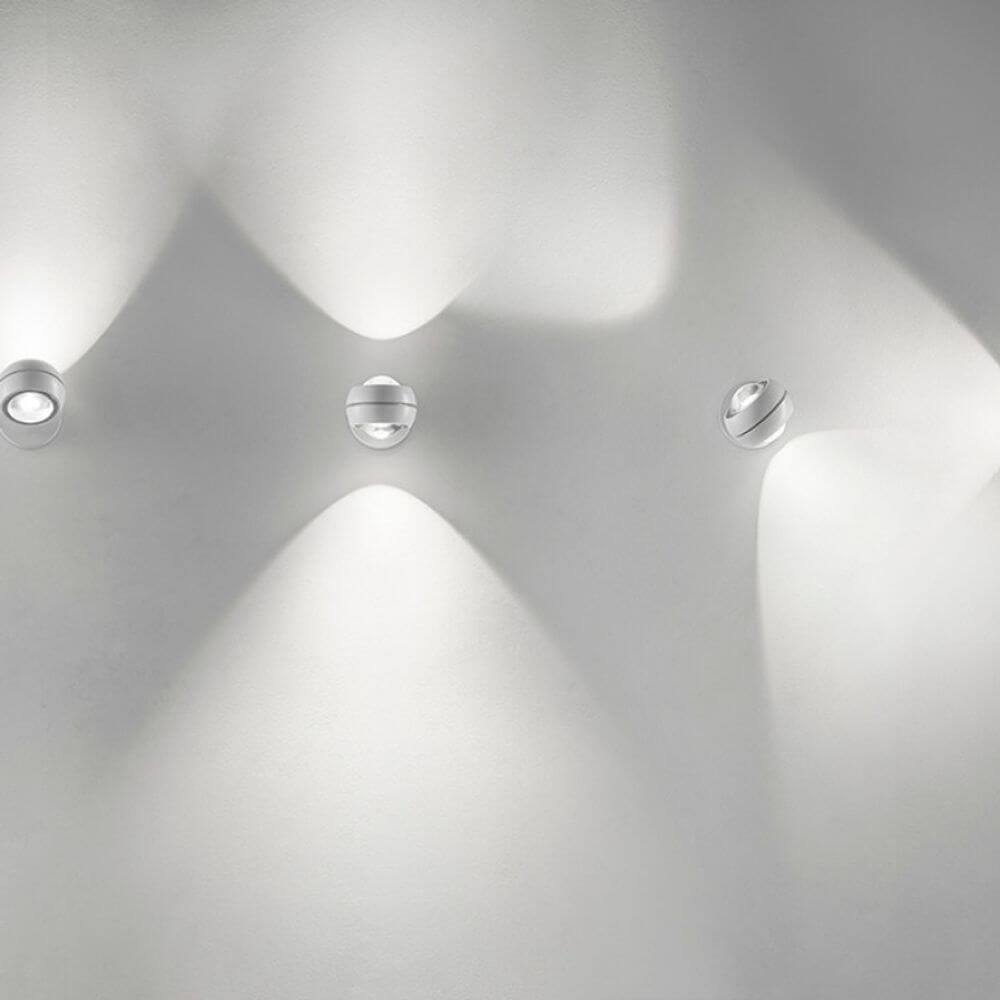 Lodes Nautilus Mini LED Wandleuchte an einer Wand, strahlendes Licht und modernes Design.