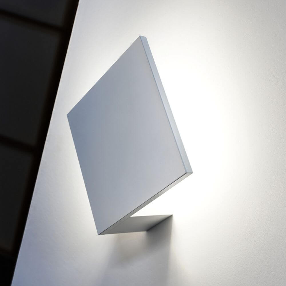 Lodes Puzzle Outdoor Single Square LED Wandlampe an einer Wand, die sanftes Licht abstrahlt.