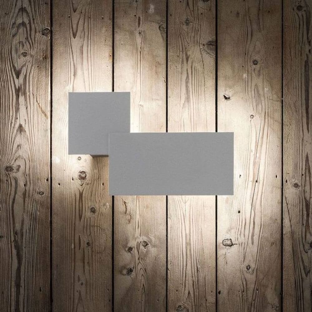 Lodes Puzzle Outdoor Square & Rectangle LED Wandlampe an holzvertäfelter Wand für stimmungsvolles Licht im Außenbereich.