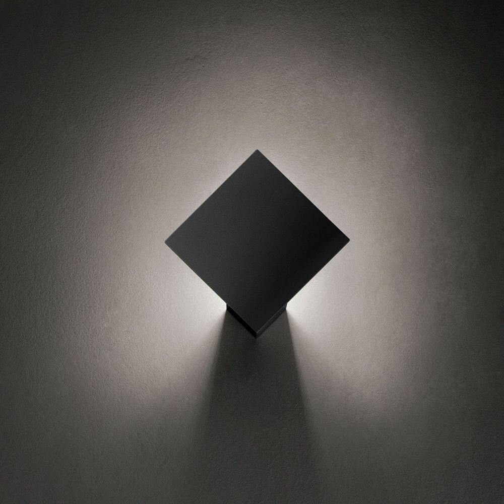 Lodes Puzzle Single Square LED Wand- & Deckenleuchte in quadratischer Form, создавая мягкое освещение на стене.