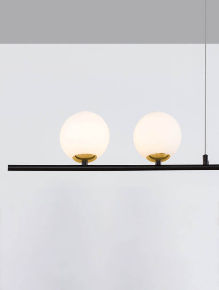 Sway Pendelleuchte Gold, Weiß, Schwarz mit zwei opalen Glaskörpern und handgebürsteter Aluminiumleiste.
