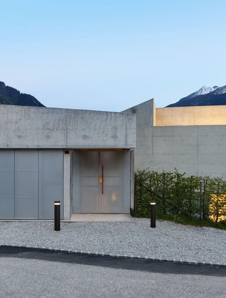 Tala LED outdoor path light with closed light outlet 3000K black IP54 in front of a modern residential building at dusk.