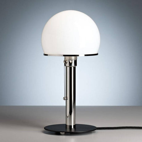 Tecnolumen Wilhelm Wagenfeld Bauhaus-bordlampe WA23SW svart på et bord med mykt lys.