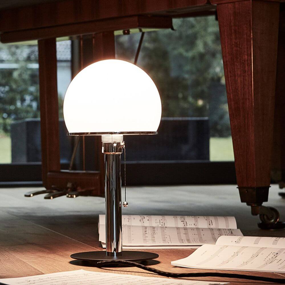 Tecnolumen Tischleuchte WA24 Wilhelm Wagenfeld Bauhaus Vernickelt auf einem Tisch mit Notenblättern.