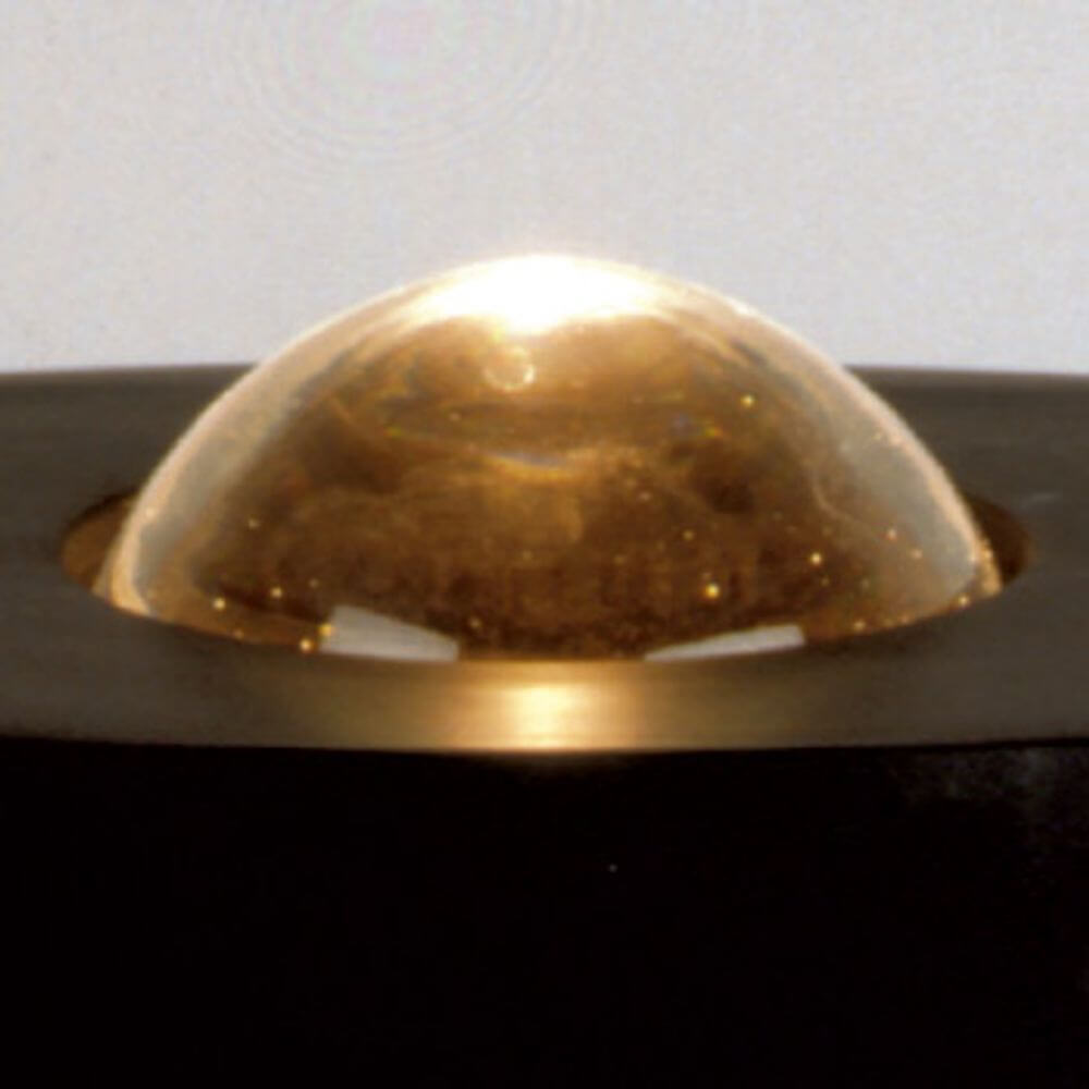 Nahaufnahme der goldenen Kuppel der Tecnolumen Egyptian Eye Bodenlampe auf schwarzem Untergrund.