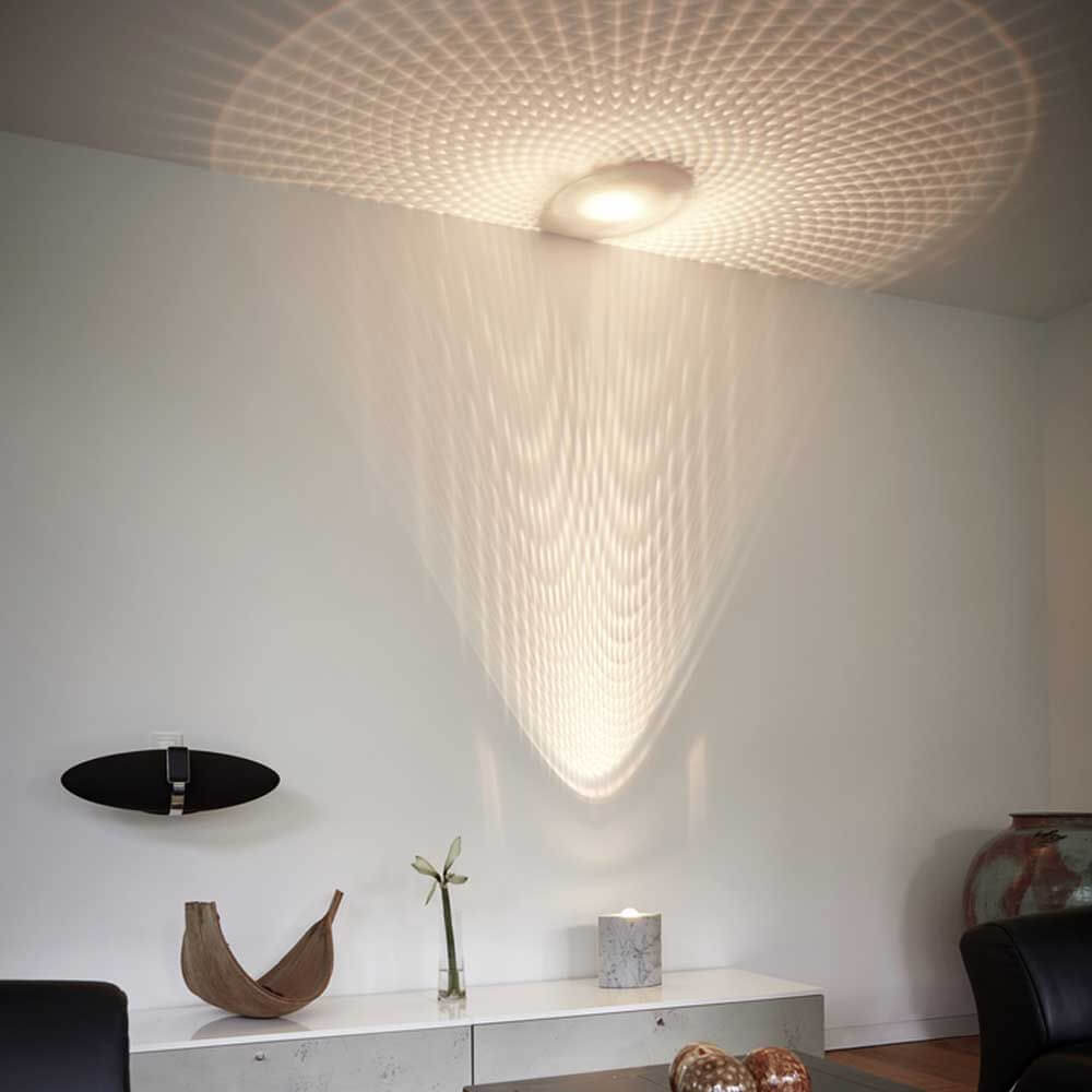 Bodenlampe Tecnolumen Egyptian Eye sorgt für beeindruckende Lichtspiele an der Wand in modernem Wohnambiente.