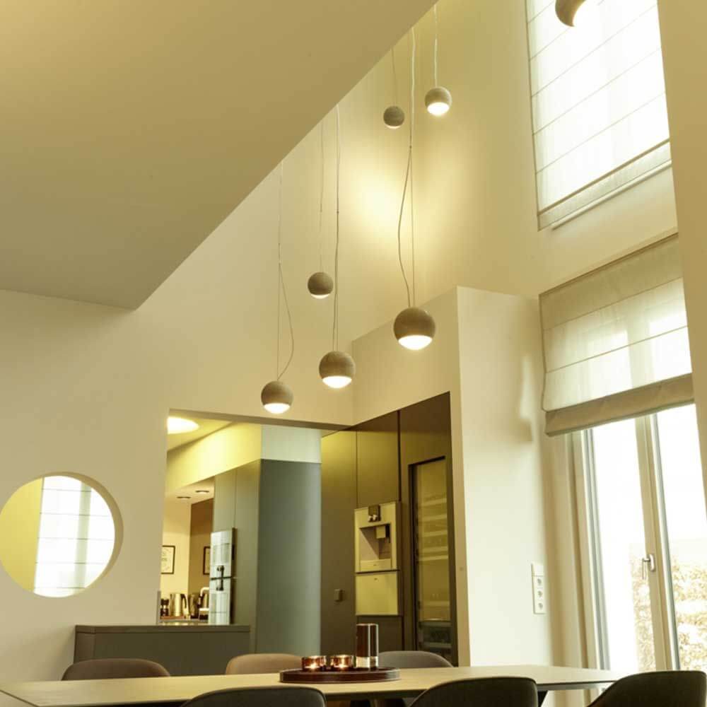 Tecnolumen Beton Pendelleuchte Trabant 1 drehbar mit Linse im modernen Wohnraum mit Betonlicht.
