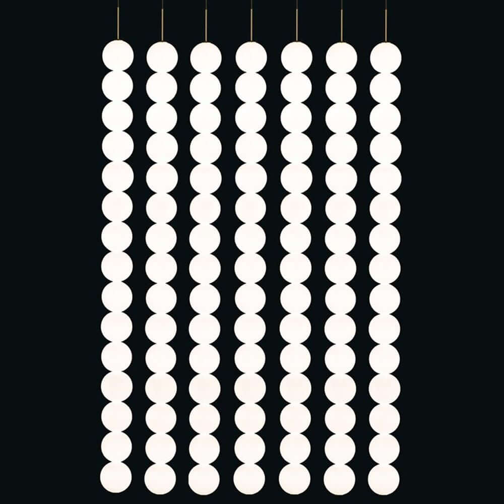 Terzani Abacus LED Design-Hängeleuchte 5er mit modularen weißen Leuchtkugeln an einem schwarzen Hintergrund.