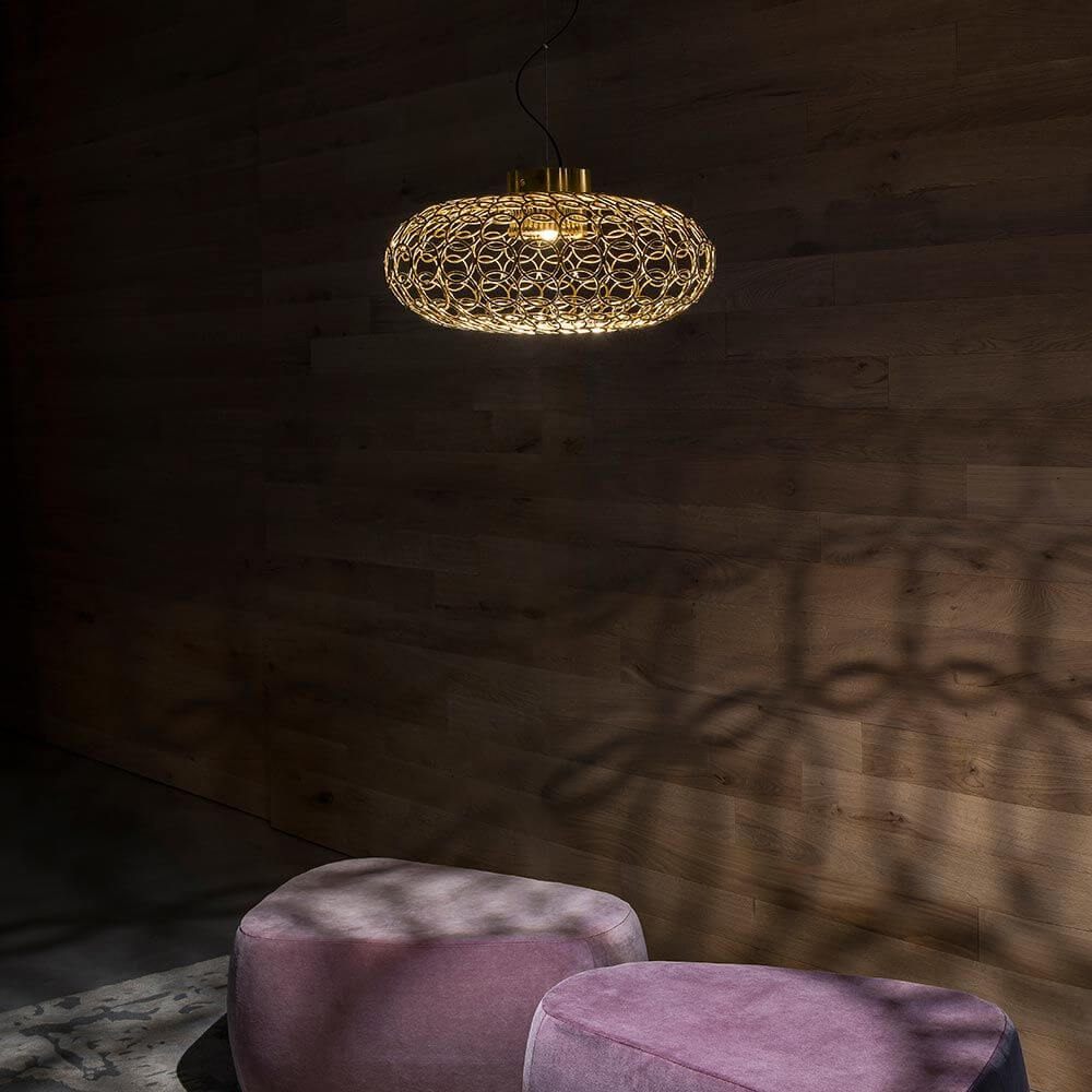 Terzani G.R.A Design-Hängeleuchte Ø 50cm in Gold, elegantes Design und weiches Licht an einer Holzwand.