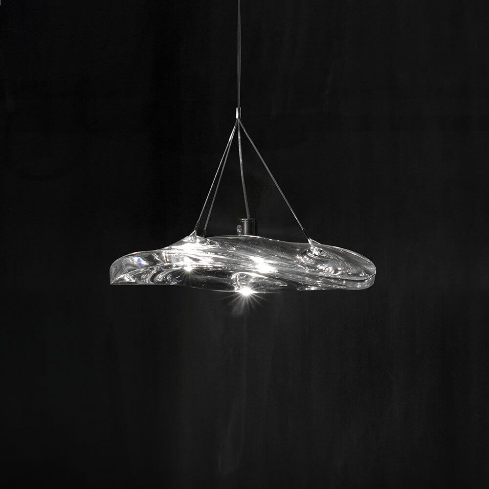 Terzani Manta LED Pendelleuchte aus Kristall mit wellenförmigem Design auf schwarzem Hintergrund.