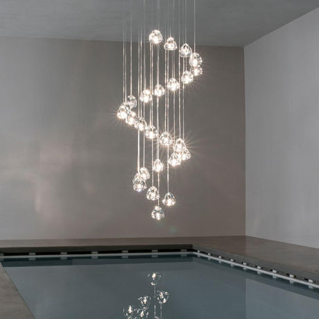 Terzani Mizu XXL Designlampe 26-flammig in einem modernen Raum über einem Pool, faszinierende Lichtbrechungen.