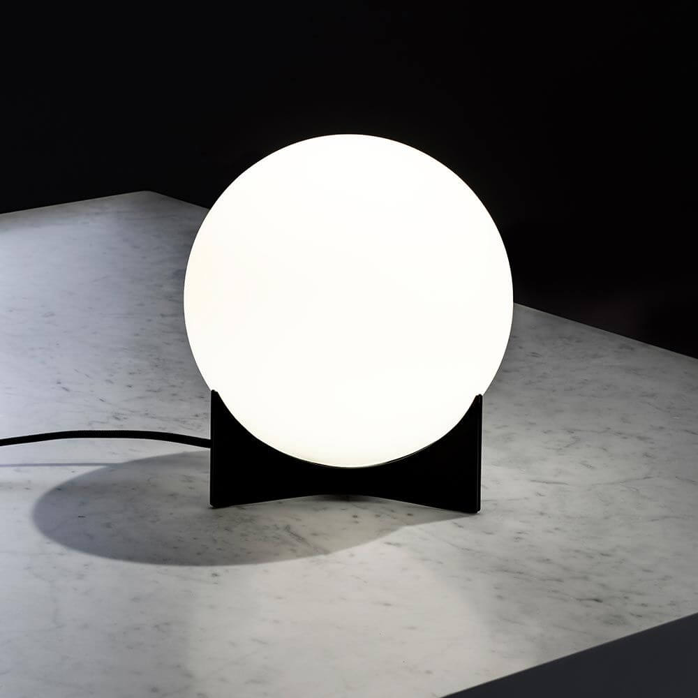 Terzani Oscar Design-Tischlampe auf einem Tisch aus Marmor, beleuchtet und modern gestaltet.