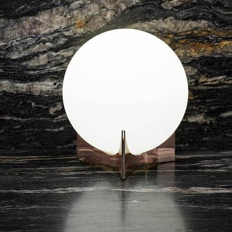 Terzani Oscar design table lamp on an elegant marble background, illuminated with soft light.