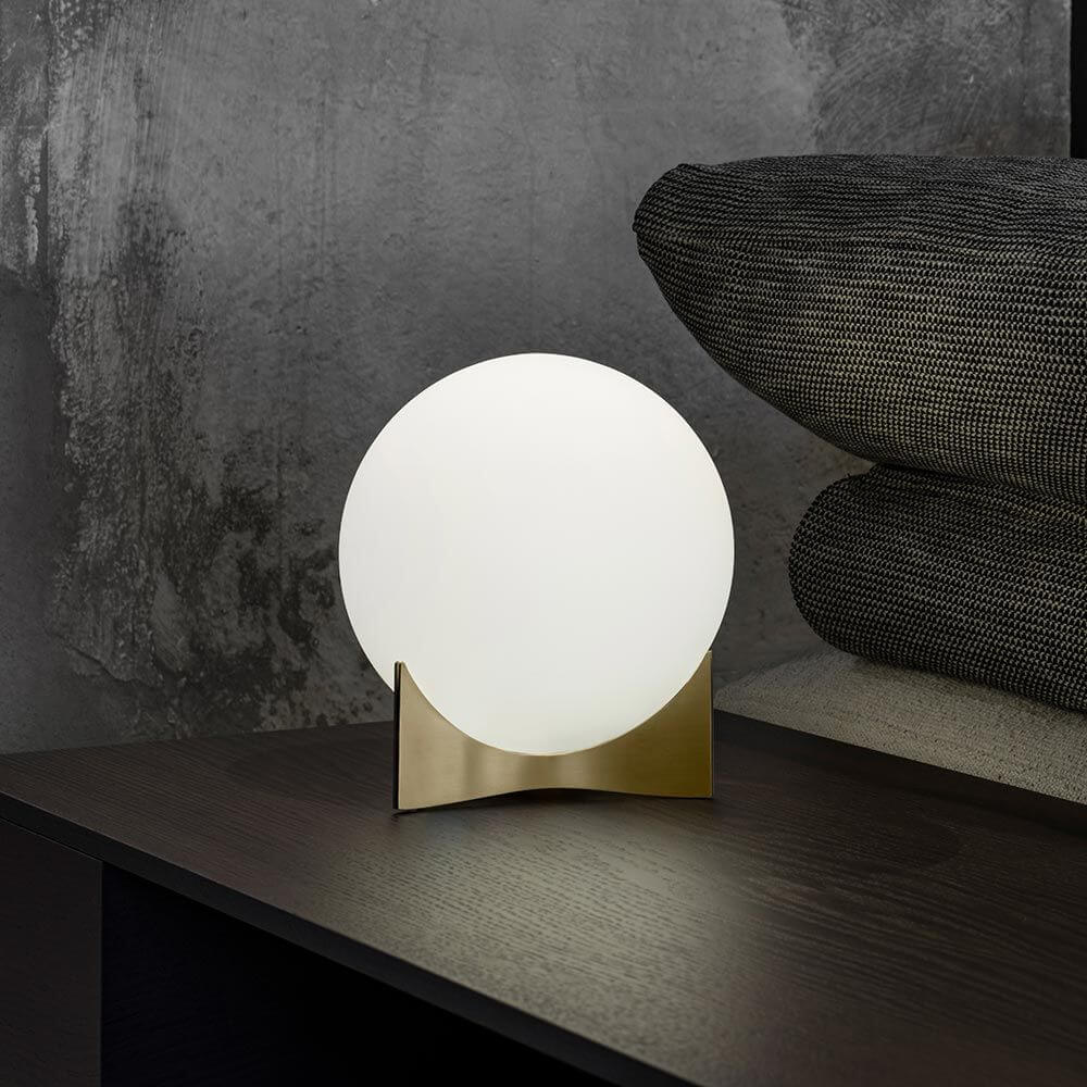 Elegante Terzani Oscar Design-Tischlampe auf einem Tisch, umgeben von modernen Kissen.