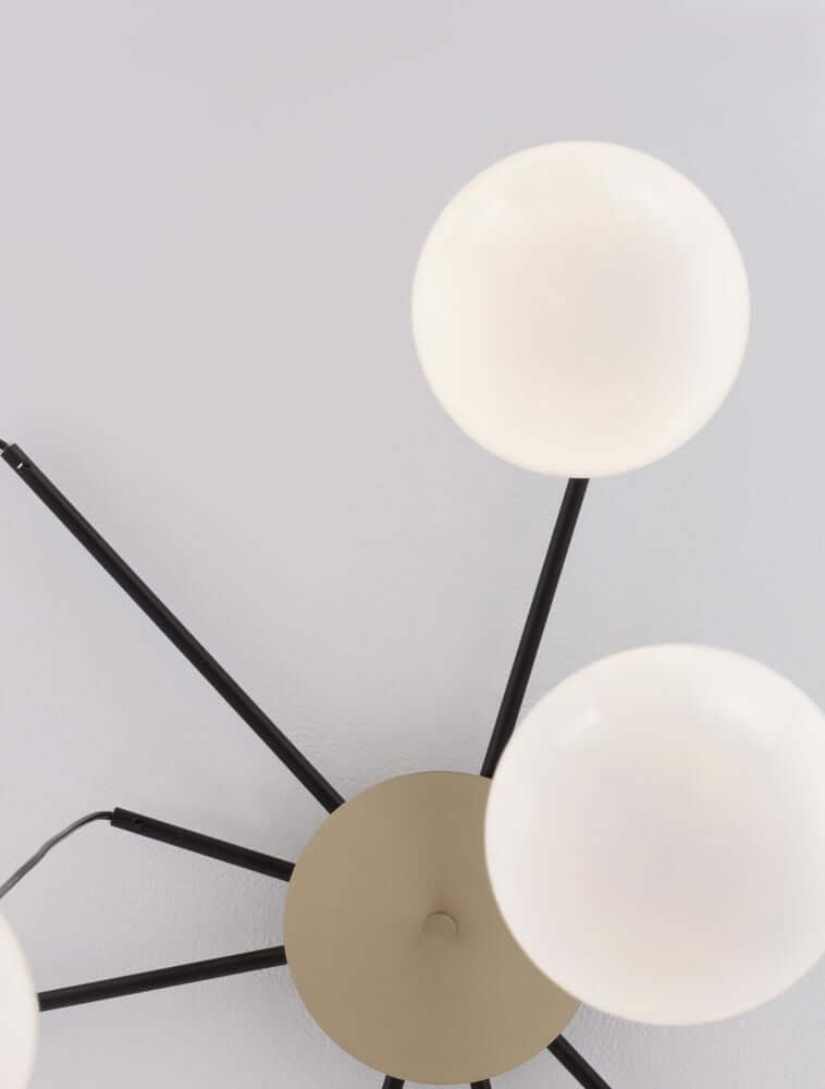 The Egg Pendelleuchte 8-flammig Ø 75cm Gold, Weiß, Schwarz mit weißen Glaskugeln und mattschwarzem Metall.