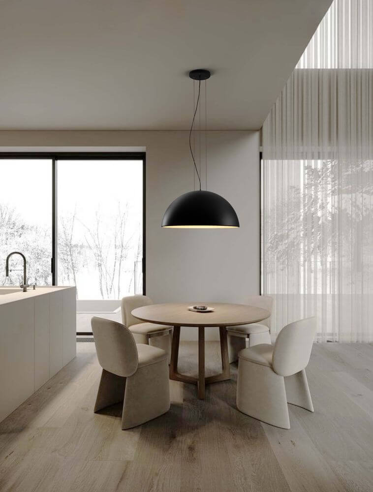 Tholos Pendelleuchte E27 3-flammig in Schwarz und Weiß über einem modernen Esstisch mit Stühlen.