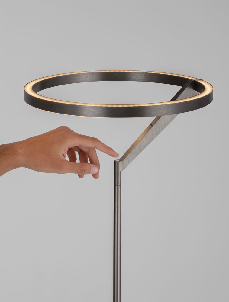 Lampe sur pied Tilia LED H 168 cm 3000K avec une main touchant le cercle lumineux, design moderne en aluminium.