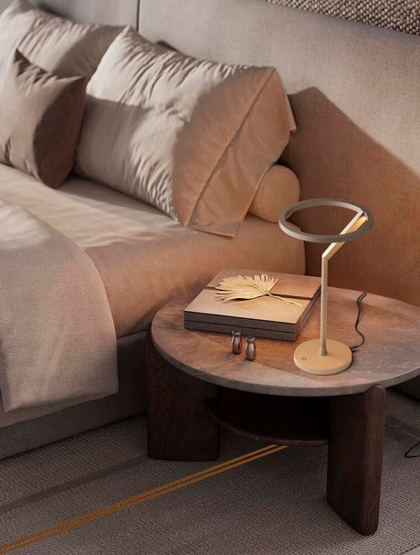 Lampe de table Tilia LED Ø 22 cm 3000K sur une table à côté d’un canapé dans un intérieur moderne.