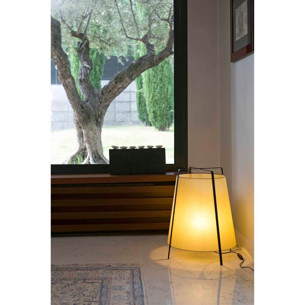Tischlampe AKANE Schwarz, Beige steht stilvoll in einem modernen Raum mit Fensterblick.