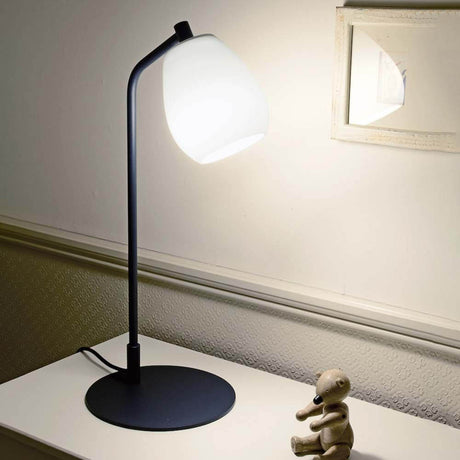 Casablanca Tischlampe Bagan auf einem Tisch mit einem Stofftier und einem Spiegel im Hintergrund.
