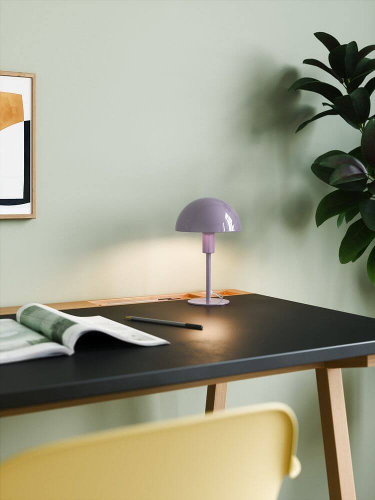Tischlampe Ellen Mini auf einem Schreibtisch mit grünem Hintergrund, ideal für minimalistisches skandinavisches Design.